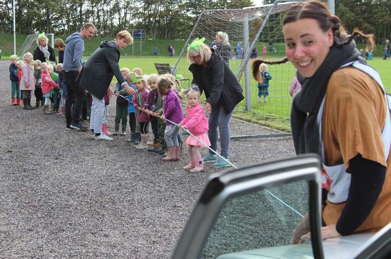 Farveladedag 2018 - dagtilbuds-børnene trækker en bil med et tov på plænerne ved Skæring Skole